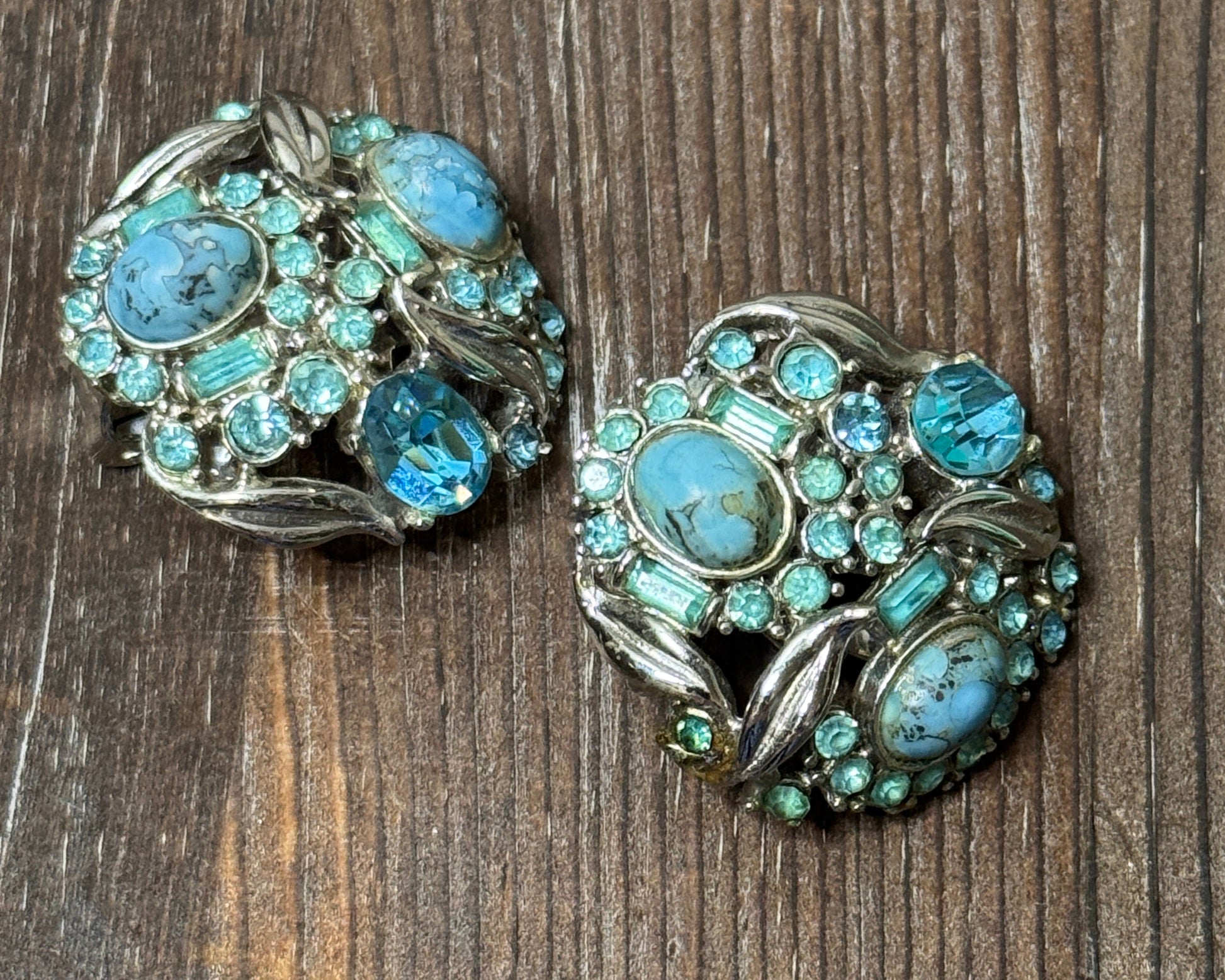 Pair of earrings with turquoise stones on a wooden surface
