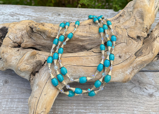 Turquoise beaded bracelets on a piece of driftwood with a natural background